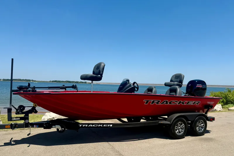 Slide: The Image of 2026 Tracker Pro Team 195 boat in vibrant red by a serene lake. - 20