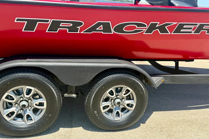 Slide: The Image of Red 2026 Tracker Pro Team 195 boat on trailer with dual wheels. - 18