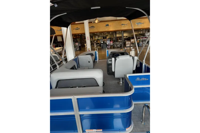 Slide: The Image of Interior view of 2026 Sun Tracker Party Barge 18 DLX pontoon boat in showroom. - 3
