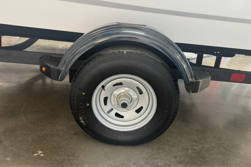 Slide: The Image of 2026 Tahoe T16 trailer wheel with black fender on concrete floor. - 2