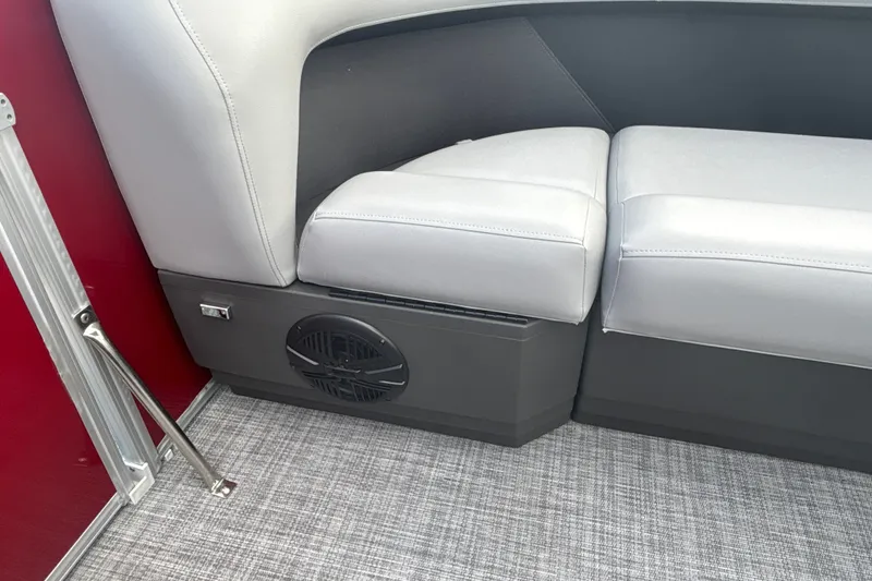 Slide: The Image of 2026 Sun Tracker Party Barge 18 DLX interior seating with speaker and red panel. - 17