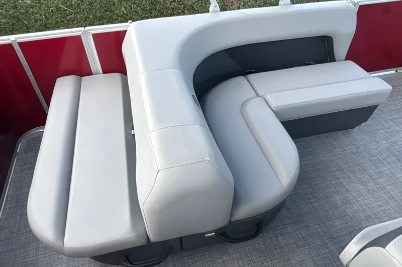 Slide: The Image of 2026 Sun Tracker Party Barge 18 DLX seating with gray upholstery and red paneling. - 21