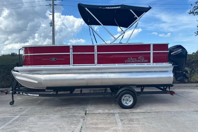 The Image of 2026 Sun Tracker Party Barge 18 DLX pontoon boat with canopy on trailer. - 0