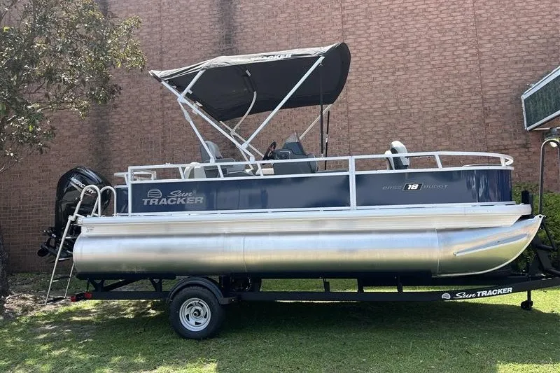 The Image of 2026 Sun Tracker Bass Buggy 18 DLX pontoon boat on trailer, parked outdoors. - 0