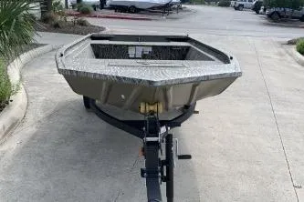 Slide: The Image of 2026 Tracker Grizzly 1648 Utility boat on trailer, parked outdoors. - 2