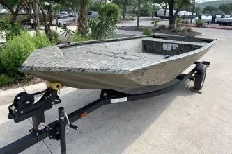 Slide: The Image of 2026 Tracker Grizzly 1648 Utility boat on trailer, parked outdoors. - 3