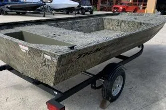 Slide: The Image of 2026 Tracker Grizzly 1648 Utility boat on trailer, featuring a camouflage design. - 5