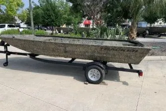 Slide: The Image of 2026 Tracker Grizzly 1648 Utility boat on trailer, parked outdoors. - 4