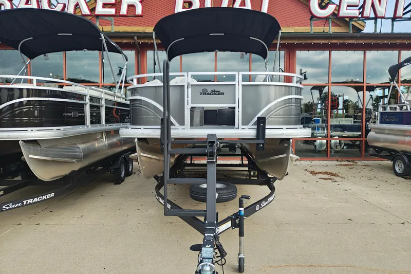 Slide: The Image of 2026 Sun Tracker Fishin' Barge 20 DLX pontoon boat displayed at dealership. - 3