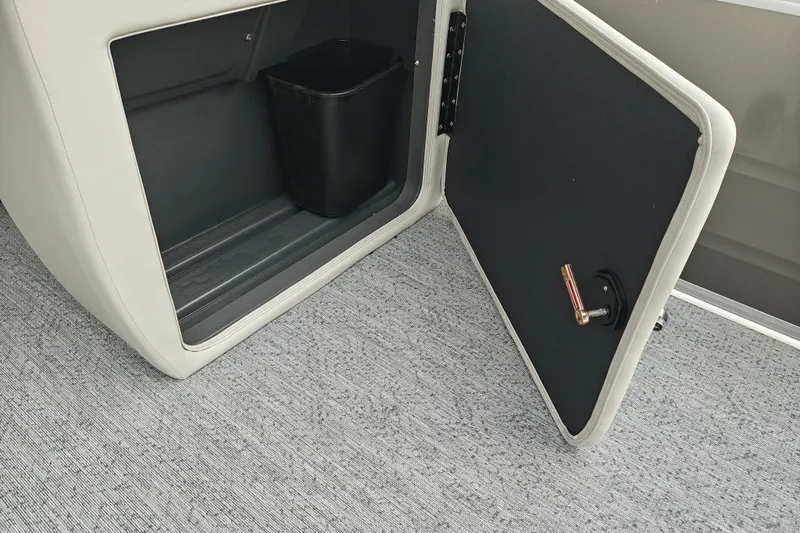 Slide: The Image of Open storage compartment on 2026 Sun Tracker Fishin' Barge 20 DLX with trash bin inside. - 13