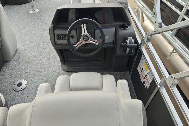 Slide: The Image of 2026 Sun Tracker Fishin' Barge 20 DLX helm with steering wheel and controls. - 28