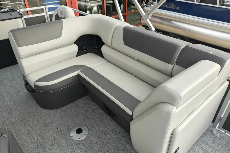 Slide: The Image of 2026 Sun Tracker Fishin' Barge 20 DLX interior seating with gray and white upholstery. - 14
