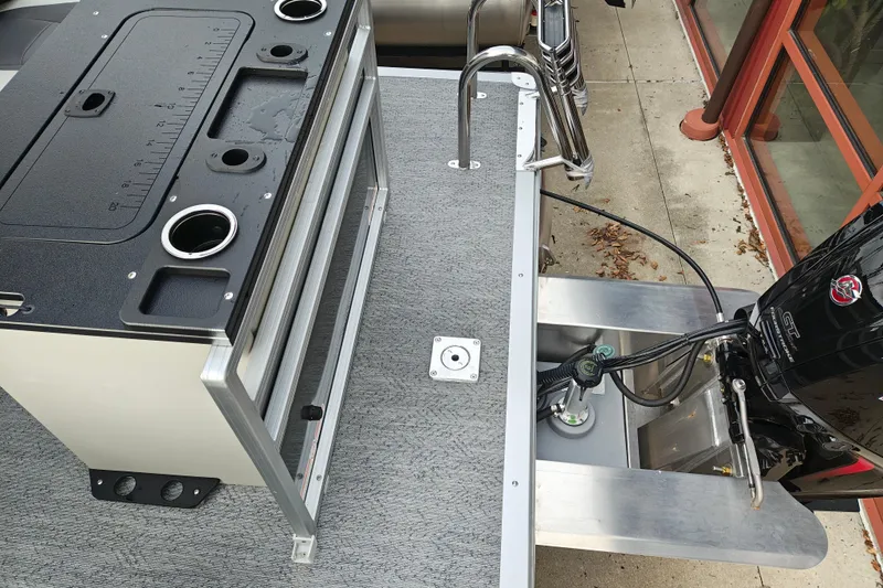 Slide: The Image of 2026 Sun Tracker Fishin' Barge 20 DLX boat deck with motor and fishing station. - 25