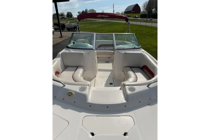 Slide: The Image of 2005 Hurricane SunDeck 187 IO boat with spacious seating and windshield, parked outdoors. - 6
