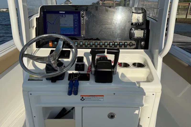 Slide: The Image of 2017 Sea Hunt Gamefish 25 helm with steering wheel, navigation controls, and electronic displays. - 13