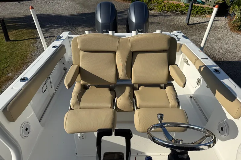 Slide: The Image of 2017 Sea Hunt Gamefish 25 boat interior with dual beige seats and steering wheel. - 21