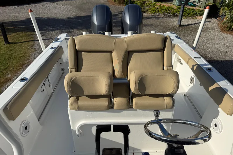 Slide: The Image of 2017 Sea Hunt Gamefish 25 boat interior with dual beige seats and steering wheel. - 22