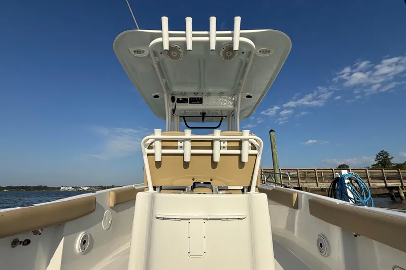 Slide: The Image of 2017 Sea Hunt Gamefish 25 boat with T-top, docked under clear blue sky. - 23