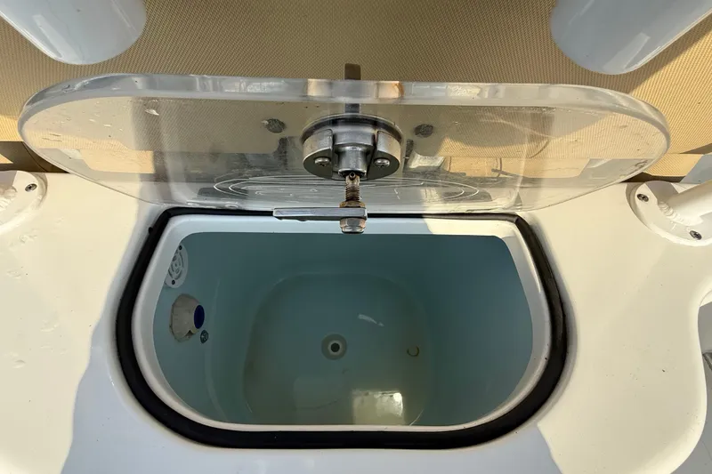 Slide: The Image of Livewell on 2017 Sea Hunt Gamefish 25 boat, featuring clear lid and drain plug. - 25