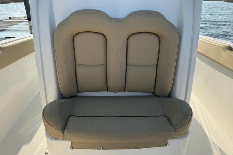 Slide: The Image of 2017 Sea Hunt Gamefish 25 boat seat with beige upholstery, dockside view. - 27