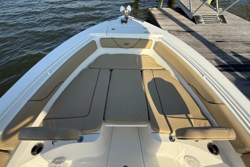 Slide: The Image of 2017 Sea Hunt Gamefish 25 boat with cushioned seating, docked by the water. - 28