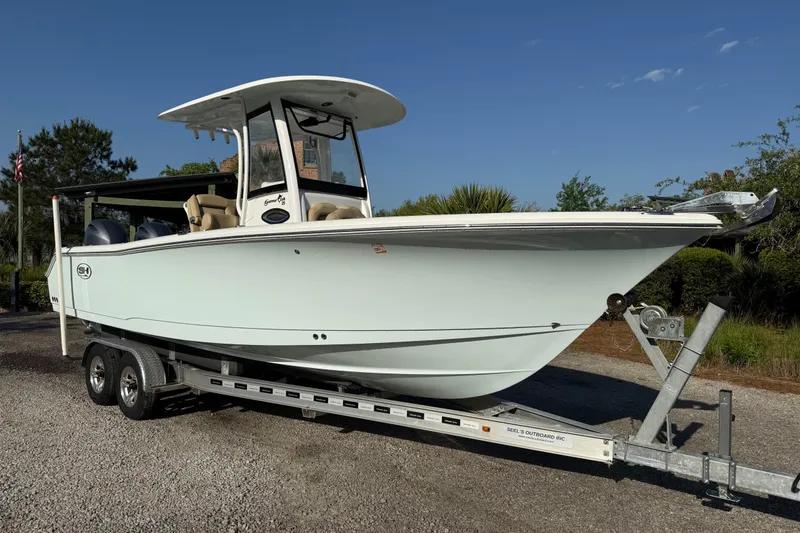 Slide: The Image of 2017 Sea Hunt Gamefish 25 boat on trailer, parked outdoors under clear blue sky. - 7