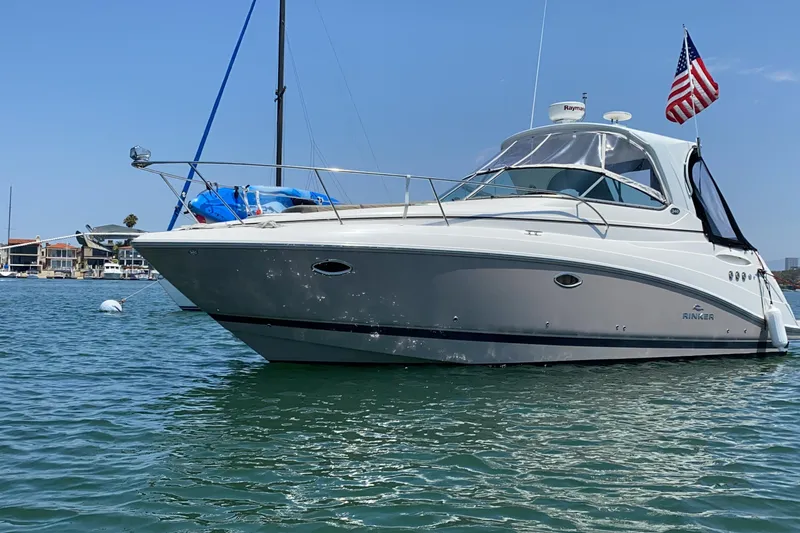 The Image of 2009 Rinker 340 Express Cruiser on water, American flag, clear sky background. - 0