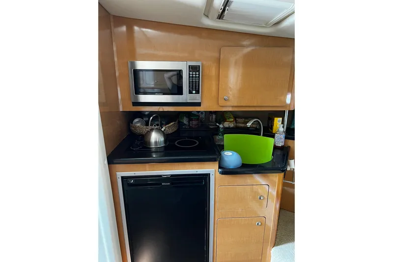 Slide: The Image of Compact kitchen in a 2009 Rinker 340 Express Cruiser with microwave and mini fridge. - 10