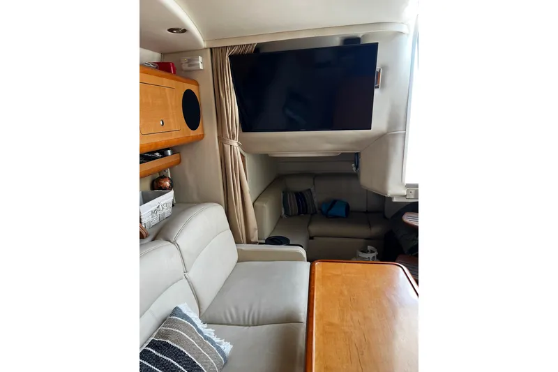 Slide: The Image of Interior of 2009 Rinker 340 Express Cruiser with TV, seating, and wooden cabinetry. - 11