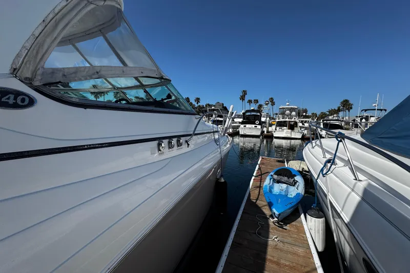 Slide: The Image of 2009 Rinker 340 Express Cruiser docked with kayak, surrounded by boats under clear blue sky. - 17