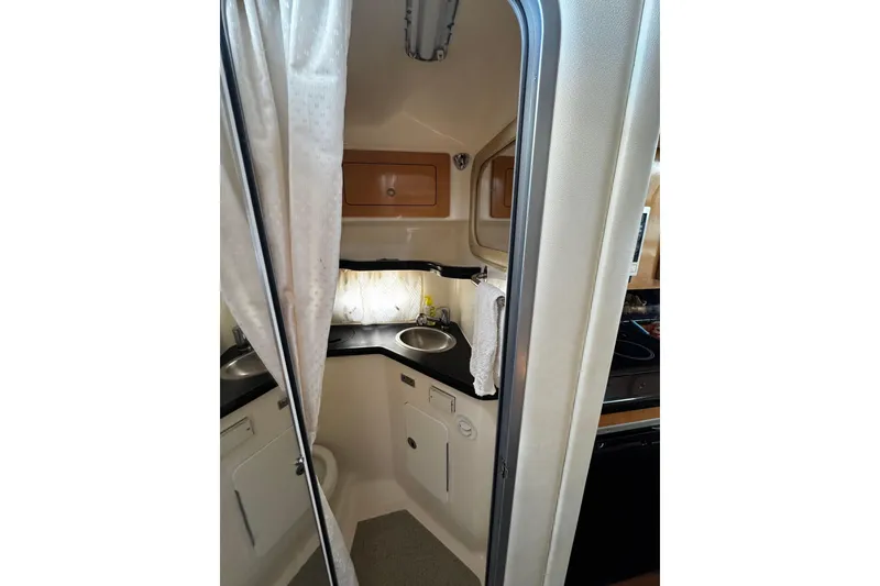 Slide: The Image of 2009 Rinker 340 Express Cruiser bathroom with sink, storage, and curtain. - 18