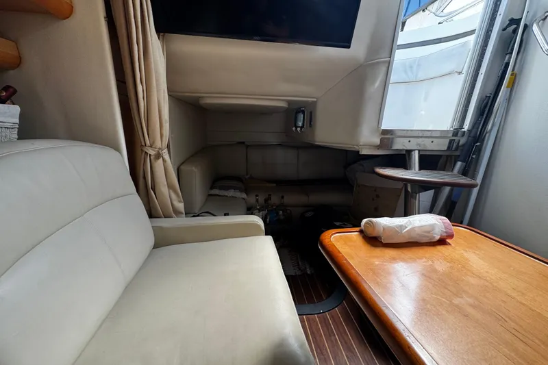 Slide: The Image of 2009 Rinker 340 Express Cruiser interior with seating, table, and cabin view. - 20