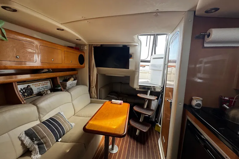 Slide: The Image of Interior of 2009 Rinker 340 Express Cruiser with cozy seating and wooden table. - 21