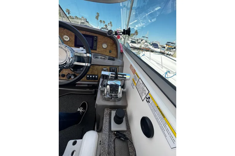 Slide: The Image of 2009 Rinker 340 Express Cruiser helm with steering wheel and control panel. - 30