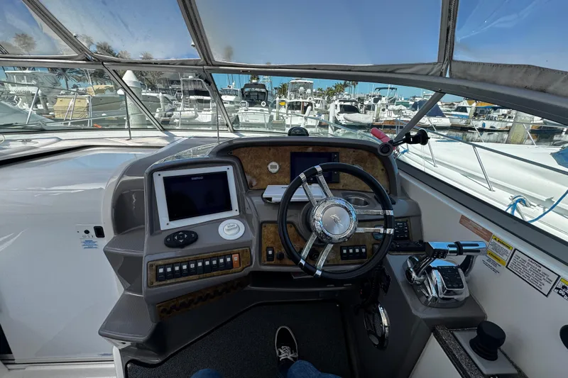 Slide: The Image of 2009 Rinker 340 Express Cruiser helm with steering wheel and navigation controls. - 31