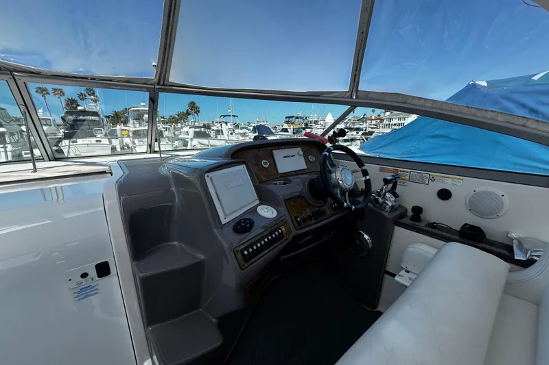 Slide: The Image of 2009 Rinker 340 Express Cruiser helm with marina view, featuring modern controls and navigation equipment. - 32