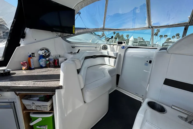 Slide: The Image of 2009 Rinker 340 Express Cruiser interior with seating, countertop, and window views. - 34