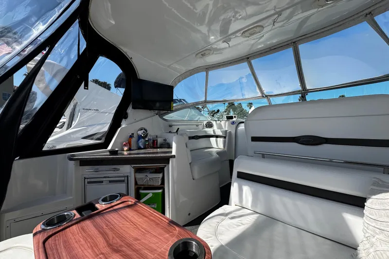 Slide: The Image of Interior of 2009 Rinker 340 Express Cruiser with white seating and wooden table. - 35