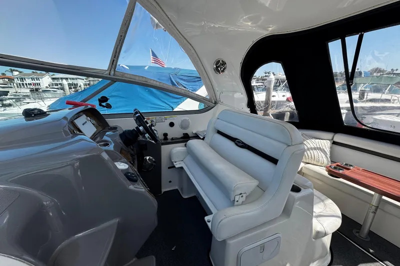 Slide: The Image of 2009 Rinker 340 Express Cruiser cockpit with white seating and marina view. - 38