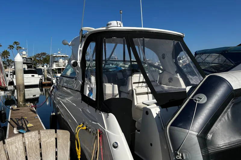 Slide: The Image of 2009 Rinker 340 Express Cruiser docked at marina under clear blue sky. - 4