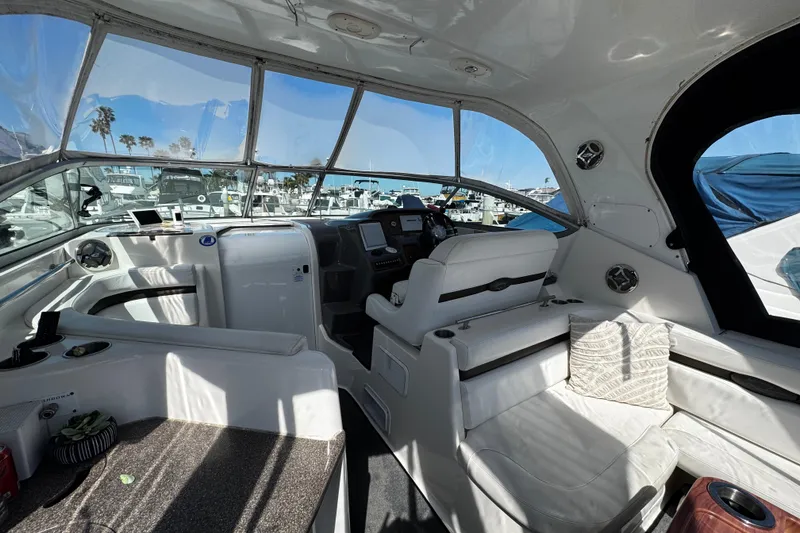 Slide: The Image of 2009 Rinker 340 Express Cruiser interior with helm, seating, and marina view. - 40