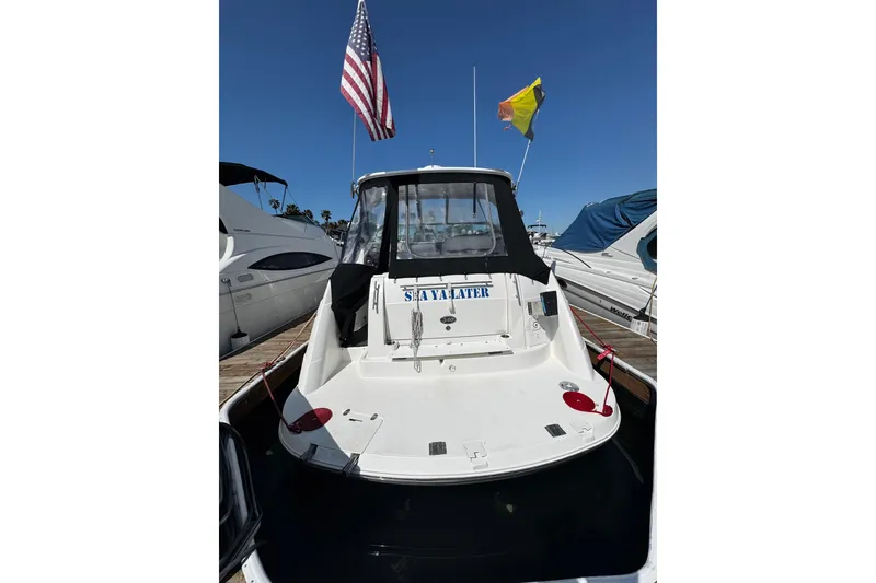 Slide: The Image of 2009 Rinker 340 Express Cruiser docked, displaying American flag, rear view. - 41