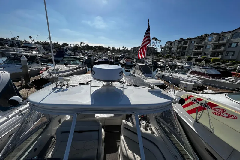Slide: The Image of 2009 Rinker 340 Express Cruiser docked in a busy marina with American flag. - 5