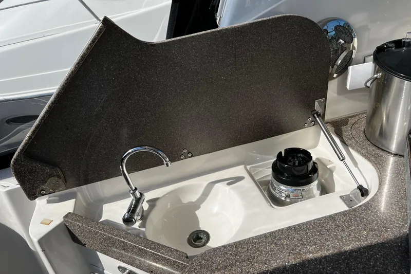 Slide: The Image of 2009 Rinker 340 Express Cruiser sink and countertop detail with faucet and storage. - 9