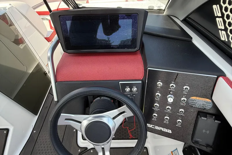 Slide: The Image of 2022 Scarab 285 ID boat dashboard with steering wheel, touchscreen, and control panel. - 15
