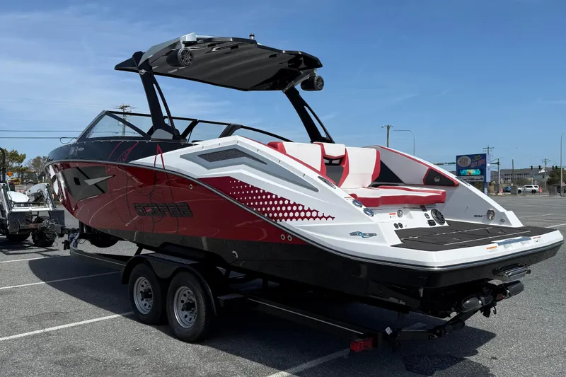 Slide: The Image of 2022 Scarab 285 ID boat in parking lot, featuring sleek red and white design. - 6