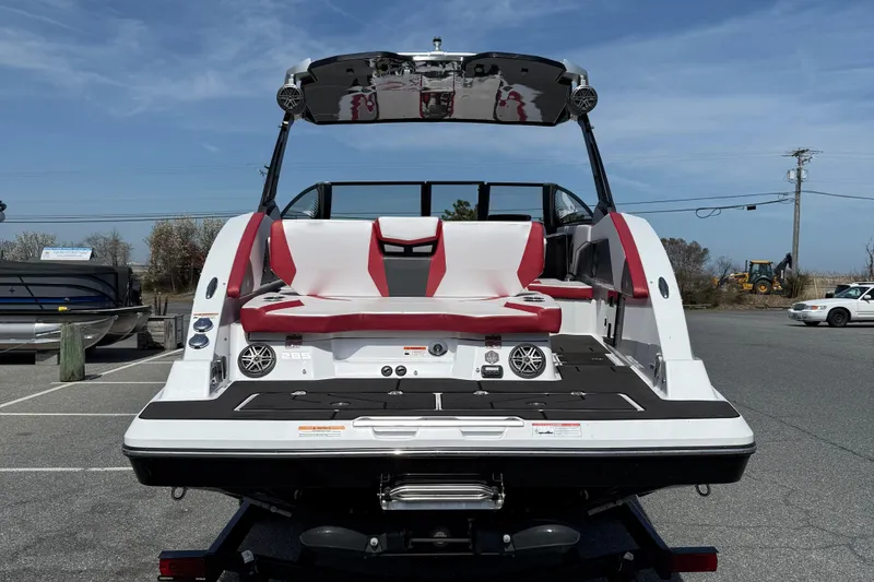 Slide: The Image of 2022 Scarab 285 ID boat, rear view, featuring red and white seating, parked outdoors. - 7