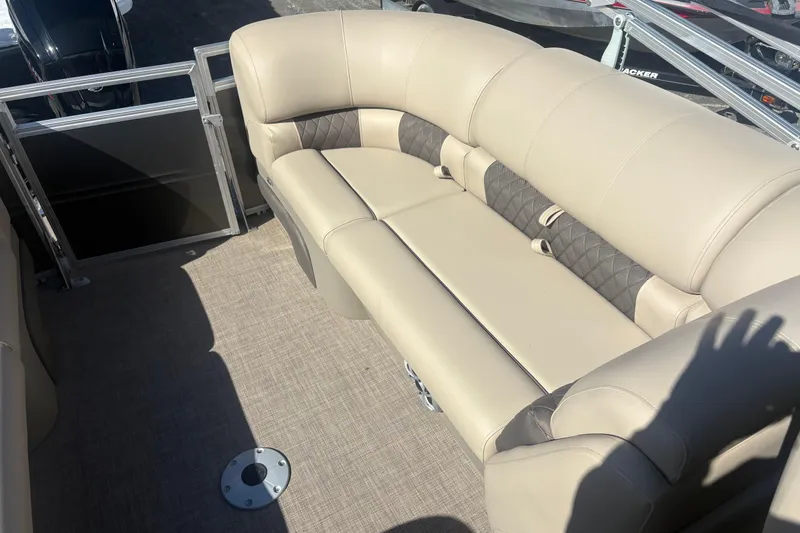 Slide: The Image of 2024 Sun Tracker Party Barge 22 DLX interior with beige seating and carpeted floor. - 10