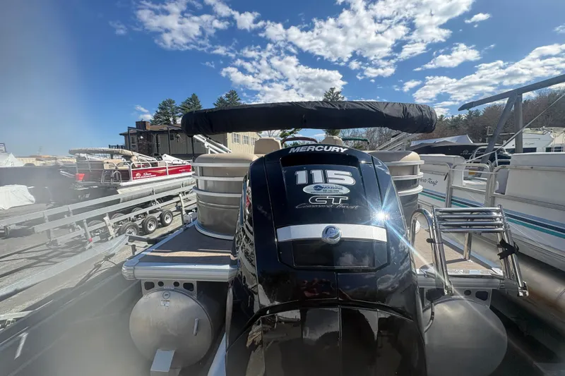 Slide: The Image of 2024 Sun Tracker Party Barge 22 DLX with Mercury 115 engine, docked under blue sky. - 3