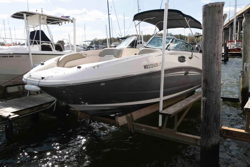 The Image of 2007 Sea Ray 260 Sundeck boat docked at marina, partially lifted from water. - 0